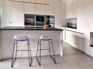 a kitchen with two bar stools and a counter at Apartment Mountain 4U by Interhome in Meiringen +19 photos