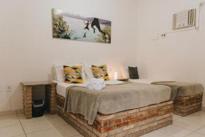 een slaapkamer met een bed en een schilderij aan de muur bij Che Lagarto Hostel Itacaré in Itacaré