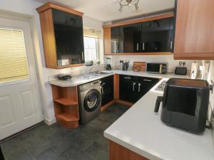 a kitchen with a washer and a sink and a stove at Swansea Escape in Swansea +19 photos