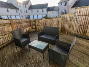 a patio with chairs and a table and a fence at Swansea Escape in Swansea