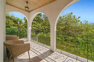 an outdoor patio with chairs and a balcony at Villa Casa Amelia Dio by Villa Plus in Caniço