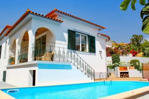 a house with a swimming pool in front of it at Villa Casa Amelia Dio by Villa Plus in Caniço
