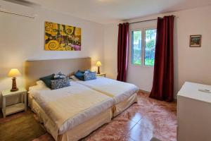 a bedroom with a large bed and a window at Villa Casa Amelia Dio by Villa Plus in Caniço +9 photos