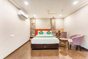 a bedroom with a bed and a desk and chairs at Treebo Premium Nagpur Automotive Square in Nagpur