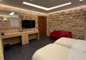 Un dormitorio con un televisor y un sofá rojo. en Villa Rosa Luxury Boutique Hotel, en Batroun 25 fotos más
