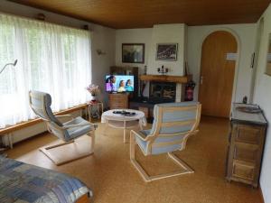 a living room with two chairs and a television at Apartment Akalei by Interhome in Aeschi