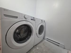 een witte wasmachine in een kamer bij Quiet Comfort Suite in Moncton