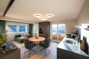a kitchen and living room with a table and a couch at Chalet Emely in Bartholomäberg