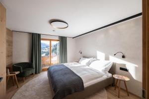 a bedroom with a bed and a large window at Chalet Emely in Bartholomäberg