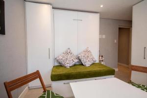 een kamer met een bank met twee kussens erop bij SeaPoint MicroStudio - Walk 2 Promenade&Waterfront in Kaapstad