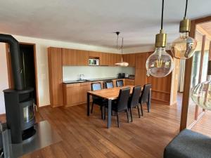 a kitchen and dining room with a table and a stove at Apartment Chasa Ernst by Interhome in Zernez