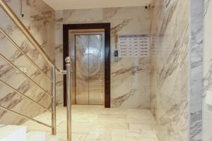 a elevator in a bathroom with marble walls at Najd Cozy Apartment in Dammam