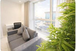 een woonkamer met een bank en een groot raam bij Najd Cozy Apartment in Dammam