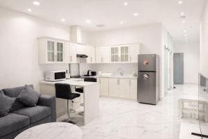 a kitchen and living room with a couch and a refrigerator at Najd Cozy Apartment in Dammam