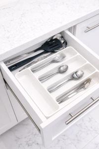 een lade in een keuken met zilveren keukengerei bij Najd Cozy Apartment in Dammam +21 foto's