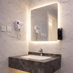 een badkamer met een wastafel en een spiegel bij Najd Cozy Apartment in Dammam