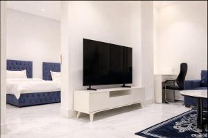 soggiorno con TV a schermo piatto e armadio bianco di Najd Cozy Apartment a Dammam