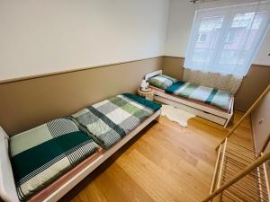 two beds in a small room with a window at Ubytování Jitřenka in Černá Voda