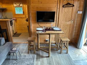 een kamer met een tafel en een tv in een hut bij Glenhill Lodge in Roybridge