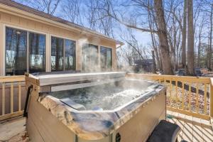 een hot tub op het terras van een huis bij 3 Fireplaces Hot Tub Fire Pit Deck Pool Access in Hedgesville