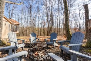 vier stoelen rond een vuurplaats in het bos bij 3 Fireplaces Hot Tub Fire Pit Deck Pool Access in Hedgesville +88 foto's