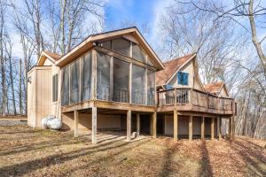 een huis met een veranda rondom met glas bij 3 Fireplaces Hot Tub Fire Pit Deck Pool Access in Hedgesville