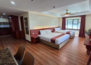 a hotel room with two beds and a table at 456 Hotel in Baguio