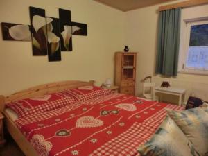 a bedroom with a red bedspread with hearts on it at Apartment Eulenrast in Loich by Interhome in Loich