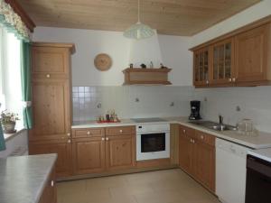 a kitchen with wooden cabinets and a white stove top oven at Apartment Eulenrast in Loich by Interhome in Loich