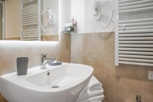 een badkamer met een witte wastafel en een spiegel bij B&B Le Stanze del Duomo in Florence
