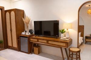 a living room with a desk with a television on it at Palma De Maldives in Thoddoo