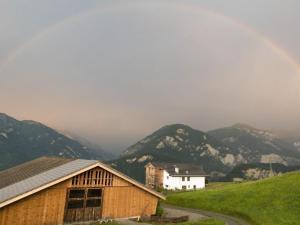 a barn on a hill with mountains in the background at Apartment Hof Quadra by Interhome in Flerden