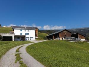 a gravel road leading to a white house and a barn at Apartment Hof Quadra by Interhome in Flerden