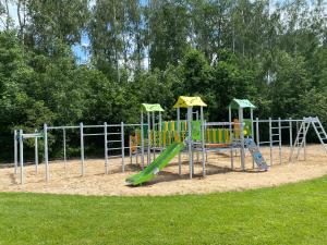 un parco giochi in un parco con scivolo verde di Hotel Cztery Pory Roku BUSINESS & SPA a Bielsk Podlaski