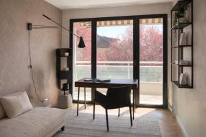 a living room with a desk and a window at Séjour réussi à deux pas de Genève appartement 57m2 in Ferney-Voltaire
