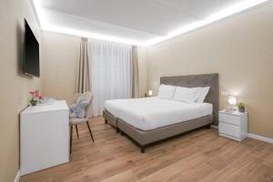 een slaapkamer met een wit bed en een tv bij B&B Le Stanze del Duomo in Florence