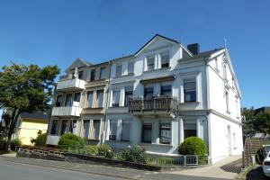 a white building with a balcony on a street at BrunnenApart Nova in Bad Oeynhausen