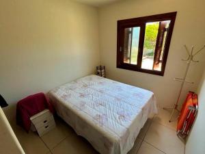 een kleine slaapkamer met een bed en een raam bij Casa aconchegante perto do mar em Imbé in Imbé