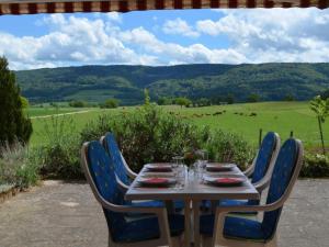 a table with chairs and a view of a field at Apartment Wohnung Bellevue by Interhome in Chevenez