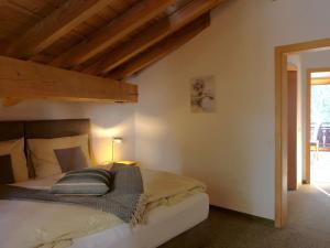 a bedroom with a bed in a room with wooden ceilings at Apartment La Stüerta by Interhome in Pontresina