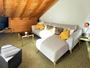 a living room with two white couches and a tv at Apartment La Stüerta by Interhome in Pontresina
