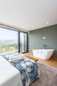 a bathroom with a tub and a bed and a bath tub at Casas Bouro 1 Casa Das Hortências in Terras de Bouro