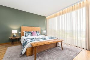 a bedroom with a bed and a large window at Casas Bouro 1 Casa Das Hortências in Terras de Bouro +43 photos