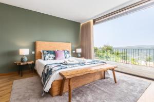 a bedroom with a bed and a large window at Casas Bouro 1 Casa Das Hortências in Terras de Bouro