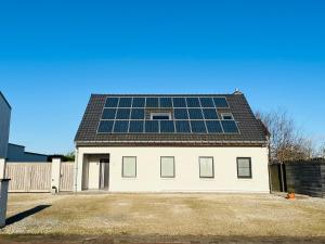 a house with solar panels on the roof at Ruime studio met eigen ingang en private badkamer in Opwijk