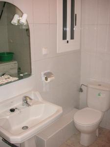 ein weißes Bad mit einem Waschbecken und einem WC in der Unterkunft Apartamentos Palmavera in Oropesa del Mar