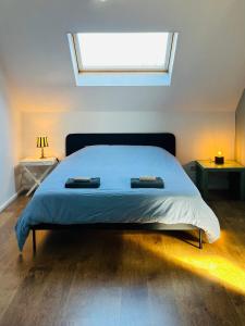 a bedroom with a bed with two tables and a window at Ruime studio met eigen ingang en private badkamer in Opwijk