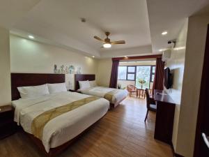 a hotel room with two beds and a desk at 456 Hotel in Baguio