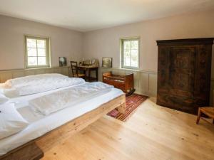 a bedroom with a large bed and a wooden floor at Holiday Home Eggwald by Interhome in Wassen