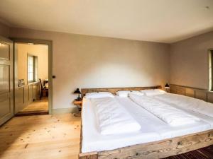 a bedroom with a large bed with white sheets at Holiday Home Eggwald by Interhome in Wassen +13 photos